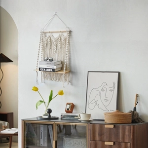 Detail of bohemian handmade cotton rope wall shelf with macrame fringe and wood shelf