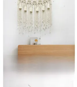 Close-up of handmade macrame wall hanging with intricate geometric knots and long fringes