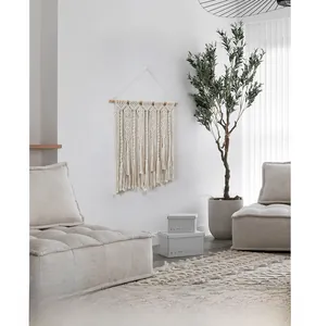 Détail d'une suspension murale macramé en coton avec franges et support en bois