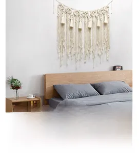 Close-up detail of hand-woven cotton macrame tapestry with bohemian style fringe