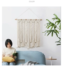 Détail d'une tenture murale en macramé avec des motifs tissés et de longues franges