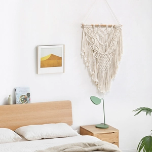 Handmade bohemian macrame wall hanging with geometric patterns and fringe tassels