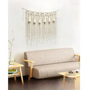 Detail of bohemian macrame wall hanging with geometric diamond weave and long cotton tassels