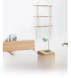 Three-tier woven cotton rope wall hanging shelf with light wood rods in boho style