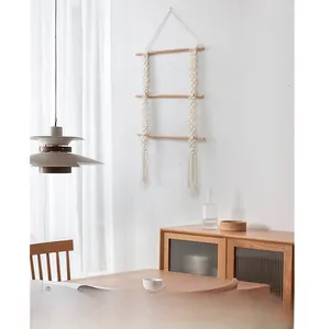 Detail of a three-tier handmade macrame wall hanging shelf with woven cotton rope