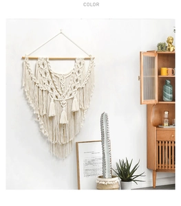 Détail d'une tenture murale macramé avec motifs tissés et longues franges en coton