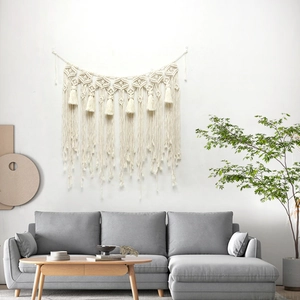 Handmade macrame wall hanging with boho fringe design in a cozy living room decor