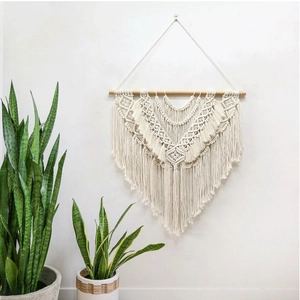 Close-up of bohemian woven wall hanging with geometric cotton patterns and tassels