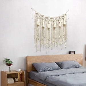 Handwoven bohemian macrame wall hanging with cotton tassels and bead accents for home decor