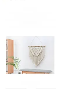 Detail of bohemian handmade woven cotton tapestry with geometric patterns and long tassels
