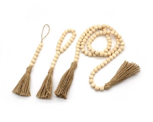 Détail d'un ensemble de guirlandes en perles de bois bohème avec glands en corde de jute