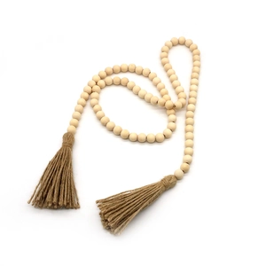 Détail d'une guirlande de perles en bois avec glands en jute et perles lisses