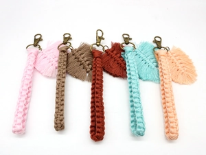Close-up of five colorful handmade bohemian macrame keychains with leaf tassels and bronze clips