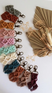 Flat lay of handmade macrame keychains in eleven colors with bohemian fringe and bronze clips