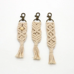 Detail showing three handmade macrame keychains with cotton rope and bronze lobster clasps