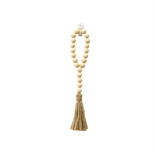 Vue détaillée d'une guirlande de perles en bois avec glands en corde de jute
