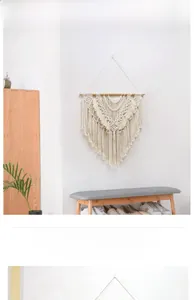 Detail of hand-woven macrame wall hanging with tiered cotton fringe on wood pole