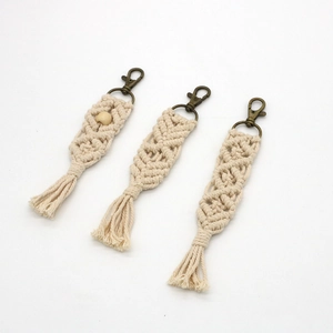 Detail of handmade cream macrame keychains with rhombus weave patterns and tassels