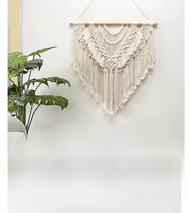 Detail of bohemian macramé wall hanging with layered tassels and handwoven geometric patterns