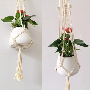 Detail of handmade macrame plant hanger showing intricate cotton rope weaving and long tassels