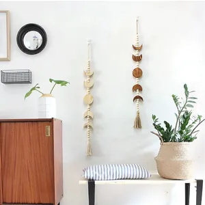 Detail of moon phase wall hanging with natural wood beads and cotton tassels