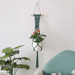 Nordic dark green macramé plant hanger with wood pole and white ceramic flower pot