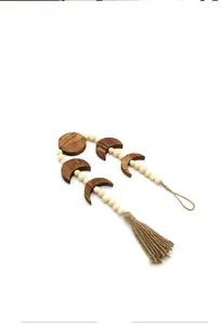 Detail of bohemian moon phase wall hanging with wooden beads and handmade cotton tassels