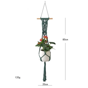 Detail of dark green macrame plant hanger with wooden bar measuring 80cm by 20cm