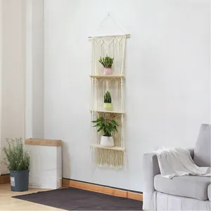 Detail of a three-tier boho woven wall shelf with white cotton rope and wood boards