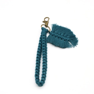 Detail view of handmade macrame leaf keychain with bronze lobster clasp in teal green cotton
