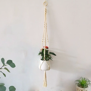 Macro detail of hand-woven macrame cotton rope hanging planter with wooden ring
