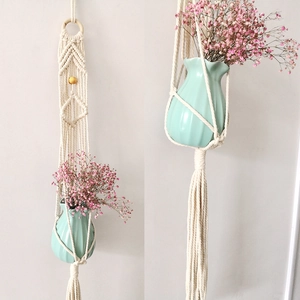 Detail of bohemian cotton macrame plant hanger with wooden ring and tassel design
