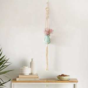 Detail of bohemian macramé plant hanger with beige cotton rope and wood ring