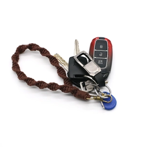 Detailed view of a brown braided rope keychain attached to a car key on white background
