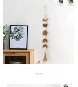Detail of wooden moon phase wall hanging with white beads and bohemian macrame tassel