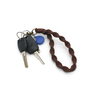 Detail of dark brown spiral woven cotton keychain with vintage bronze metal clasp