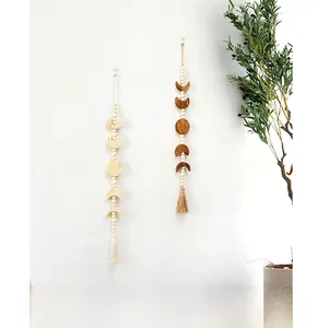 Detail of Nordic moon phase wall hanging featuring wood beads and cotton tassels