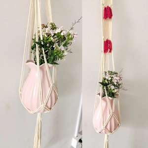 Detail of macramé plant hanger with pink tassels and a ceramic vase home decor