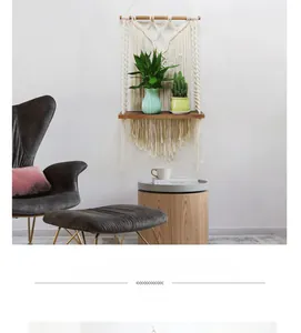 Detail of bohemian macrame wall shelf with cotton tassels and a natural wood shelf board