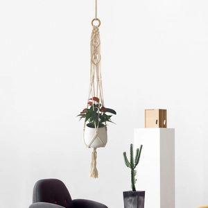 Detail of bohemian cotton rope plant hanger with handcrafted macrame knots and wooden ring