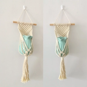 Detail of handcrafted macrame wall hanging planter with woven cotton rope and wood rod