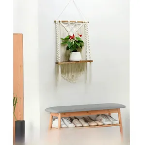 Detail view of a handcrafted macrame wall shelf with cotton rope and wood tray