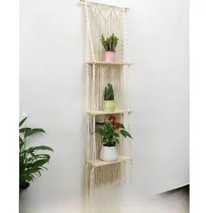 Detail of bohemian macrame wall hanging with 3-tier wooden floating shelves for plants