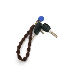 Close-up of brown spiral cotton braided keychain with bronze metal hook detail