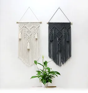Close-up of bohemian woven cotton wall hanging with intricate geometric patterns and tassels