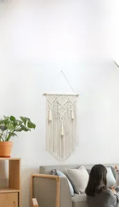 Detail of handcrafted boho macrame wall hanging with geometric weave and cotton fringe