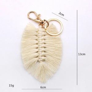 Macro view of handmade woven cotton feather keychain with metal ring and dimensions