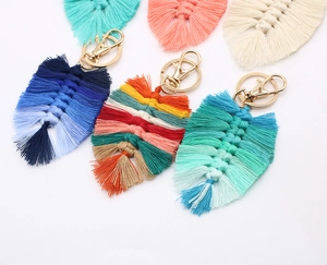 Close-up of handmade woven cotton feather keychains in various colorful gradient styles