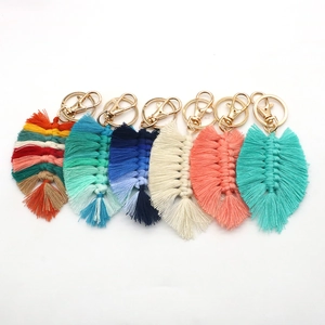 Detail of six handmade macrame feather keychains in various colors with golden clasps