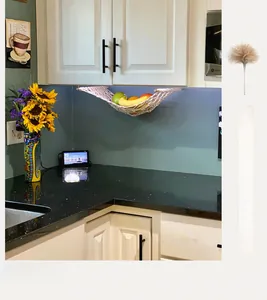 Detail of hand-woven cotton fruit hammock installed under a modern kitchen cabinet